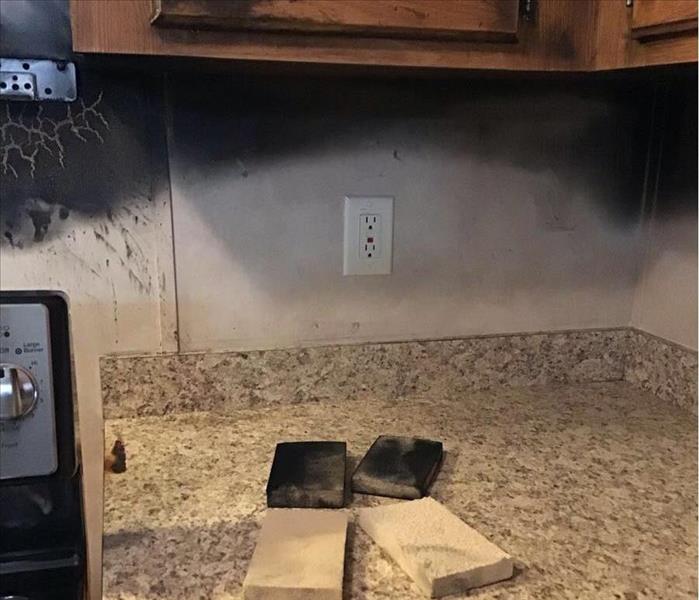 a wall above the stove with a black smoke stain