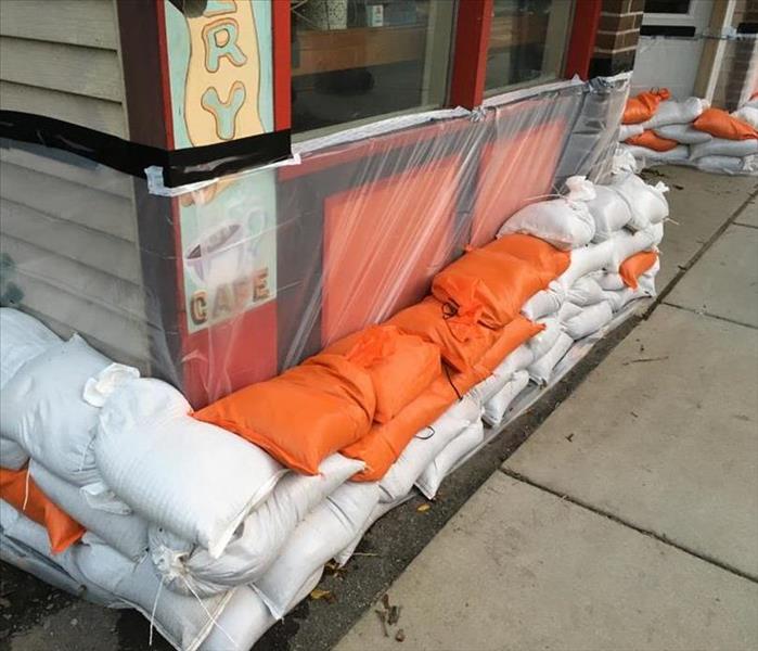 A Business protected from flooding with sand bags and plastic film